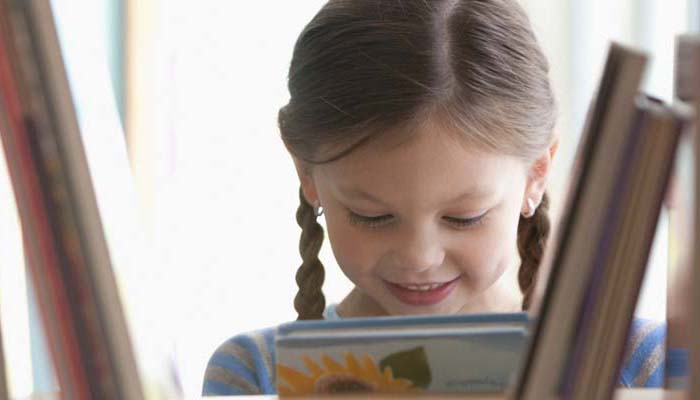 Caucasian girl taking book from shelf